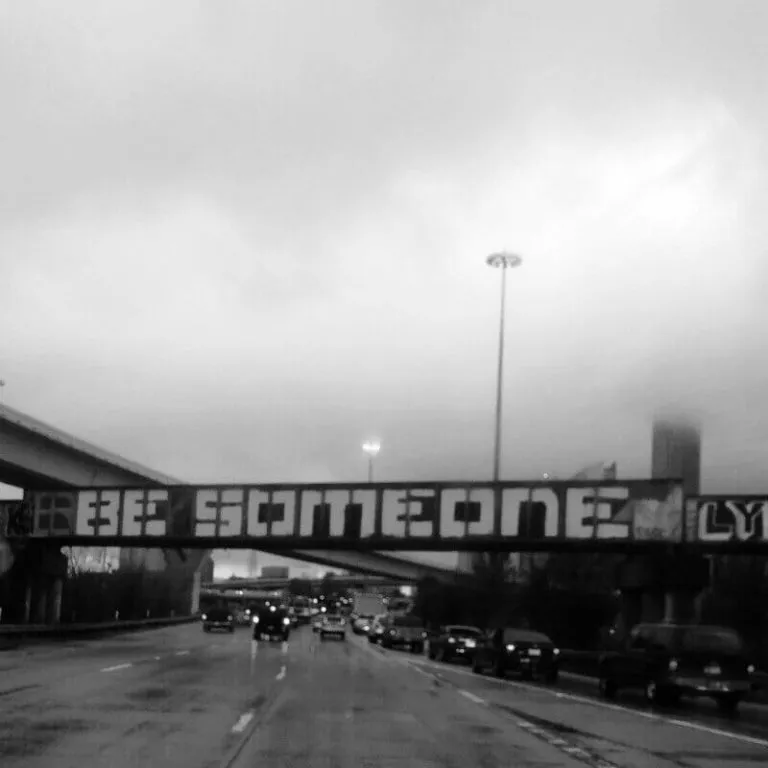 Graffiti on an overpass that says "Be Someone"