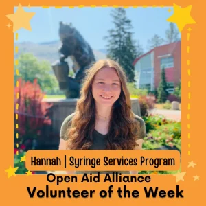 Picture of a volunteer in front of the University of Montana Griz statue